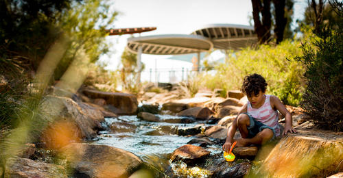 A child playing by a creek at Banksia Grove